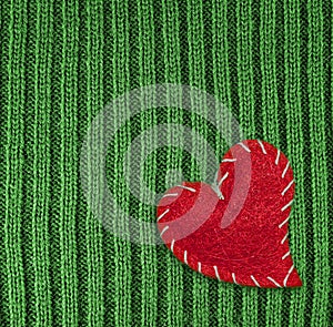 Heart on green knitted wool background