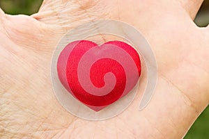 Heart in hand. Romantic concept. Big red heart in womanÂ´s open palm. Symbol of love to everybody