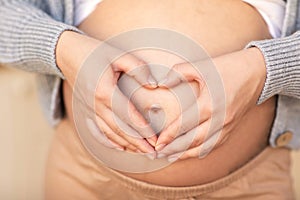 heart in the hands of a pregnant woman close-up