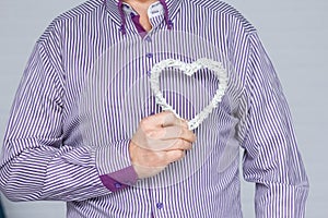 A Heart in human hands on white brick background