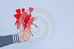 A Heart in human hands on white brick background