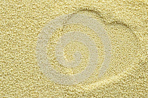 A heart imprinted in couscous. Symbol of heart graven on couscous groats background. Heart stamp. Heart prints