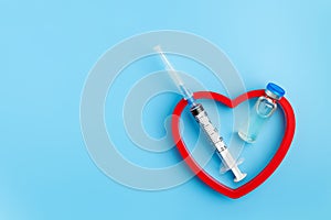 Heart Injection And Vaccine Vial. Covid-19 Cure. Medical Ampoule Dose And Needle On Blue Background,