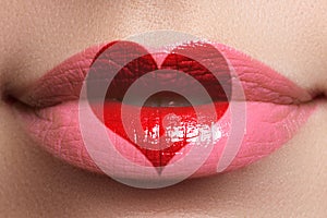 Heart kiss on the Lips. Beauty full lips with heart shape paint. Valentines Day. Beautiful make-up. Lipstick and lipgloss photo