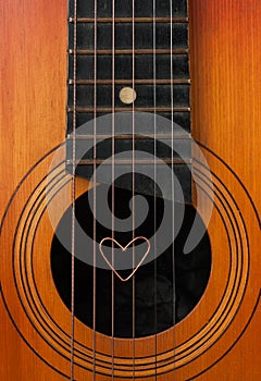 A heart lies on strings the guitar