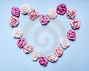 Heart, lined with paper roses on a blue background top view close up decorations for Valentine's Day top view close up