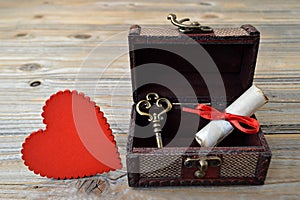 Heart, love letter and key in wooden treasure chest