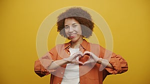 Heart, Love, Peace Gesture or Symbol by a Woman on Yellow