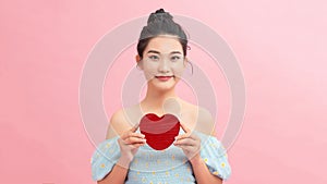 Heart. Love symbol. Portrait of beautiful woman hold Valentine day symbol. Isolated studio background female model. Beautiful girl