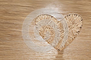 Heart made of bejeweled linen on a background of oak board