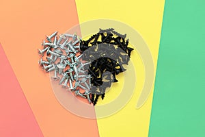 Heart made of black and gray hardware on a rainbow background