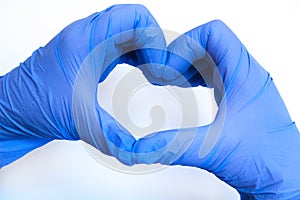 Heart made of blue gloves on a white background. gloved hands photo