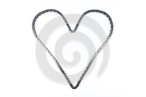 Heart made of car engine chain on a white background.