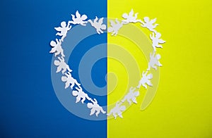 heart made of cut paper angels on a yellow-blue background in colors of Ukrainian flag