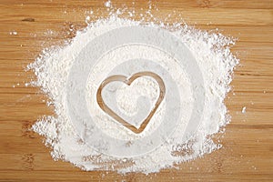 Heart made of flour on a wooden bamboo background