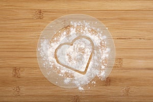 Heart made of flour on a wooden bamboo background