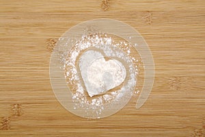 Heart made of flour on a wooden bamboo background