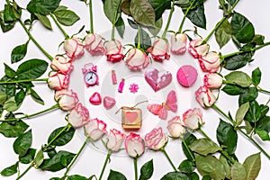 Heart made of fresh pink roses flowers and holiday decorations on white background. Greeting card, happy Valentine`s day concept.