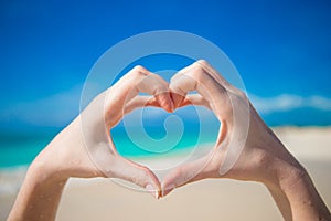 Heart made by hands background the turquoise ocean