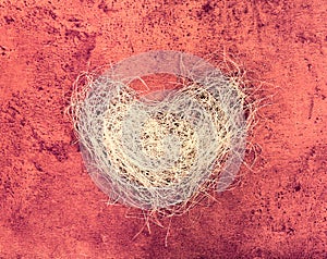 Heart made of a loofah on marsala grunge background