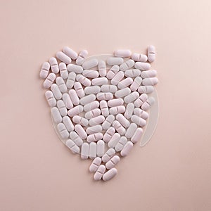 Heart made of pills on pink background. Creative concept for Valentine's Day or Pharmacy, Dietary Supplement and Cardio