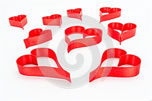 Heart made from red, satin ribbon on white background with clipping path. Valentines Day concept.