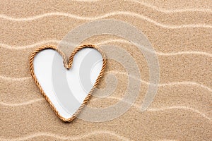 Heart made of rope with a white background on the sand
