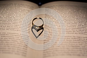 A heart made from the shadow of a ring on a book