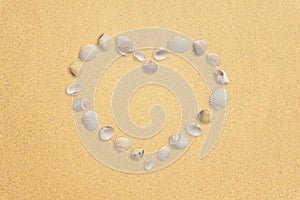 Heart made of shells on the sand with free space for text