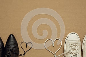 Heart made of shoelaces between men`s and women`s shoes, space for text, valentines day background