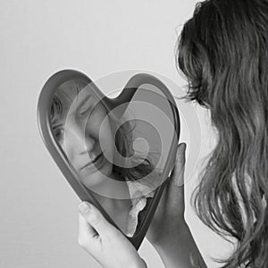 Heart mirror reflecting face of girl monochrome image