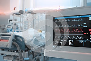 Heart monitor with ECG lines on the background of critical patient in the intensive care unit