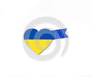Heart with national flag colours of Ukraine and fabric ribbons with flag of European Union on white background. Europe. Copy space