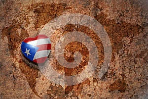 Heart with national flag of puerto rico on a vintage world map crack paper background.