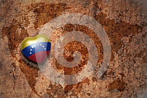 Heart with national flag of venezuela on a vintage world map crack paper background.