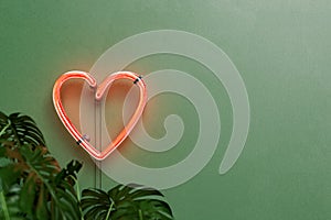 Heart neon lamp on a green wall