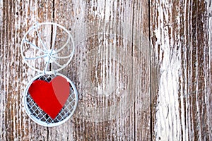 Heart in open cage on grunge wood