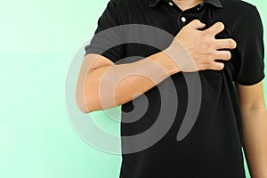 Heart pain, attack, ache, and heartburn concept. Young Asian man grabbing or holding his chest area.