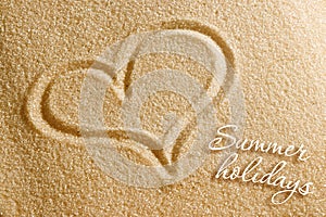 The heart is painted in the sand. Beach background. Top view. The concept of summer, summer kanikkuly, vacation, holydays