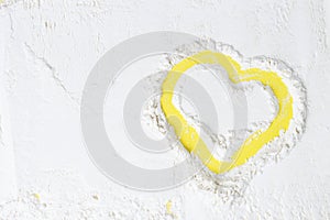 Heart painted on scattered flour, a yellow background