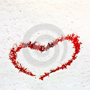 Heart painted on the snow-covered windshield of a car.