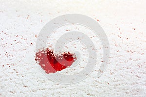 Heart painted on the snow-covered windshield of a car.