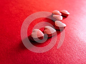 Heart pills in red background. Valentines day photo