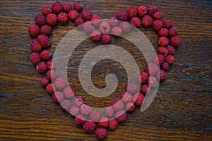 Heart from raspberry on wood background