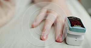 The heart rate monitor on the baby`s finger measures the pulse and blood oxygen saturation