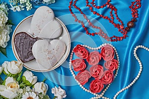 Heart of red flower buds on a blue beautiful fabric with beads of pearls and coral top view