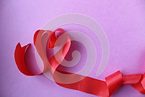 Heart of red ribbon on pink background with copyspace place for the text of the background Valentine`s Day lovers