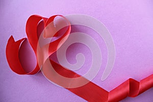 Heart of red ribbon on pink background with copyspace place for the text of the background Valentine`s Day lovers