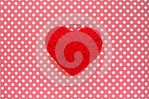 Heart of red threads on a background of cloth in polka dots. Red