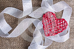 Heart and ribbon on burlap Background. Wedding Love Concept